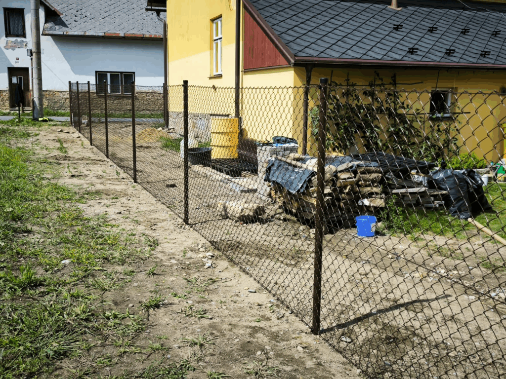 Nový plot - zabetonované sloupky a natažené pletivo