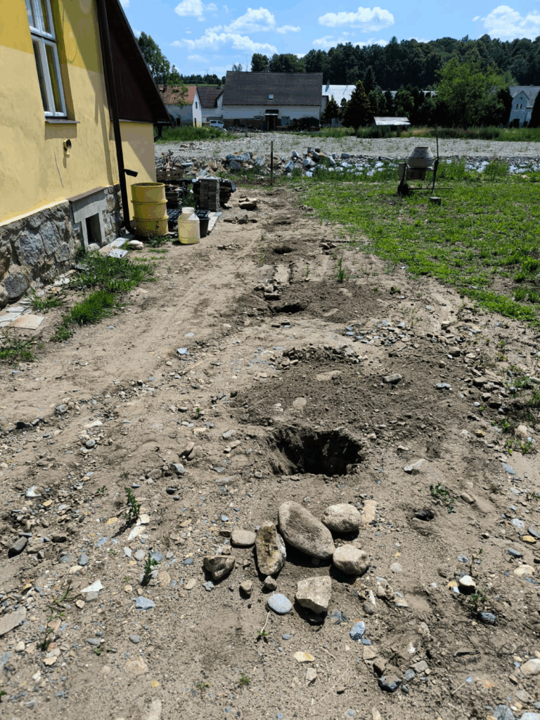 Vykopané jámy k zabetonování sloupků plotu